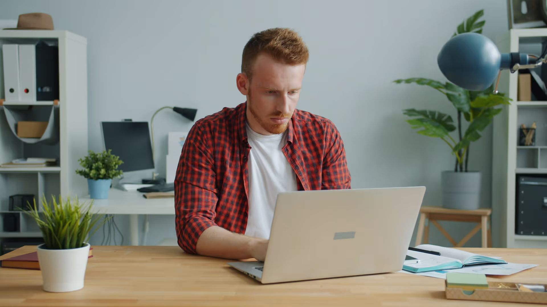 Brisbane service business owner in plaid shirt reviewing Facebook Ads campaign results on laptop