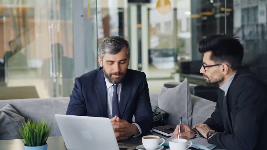 Two business professionals reviewing SEO strategy in a consultation meeting with laptop
